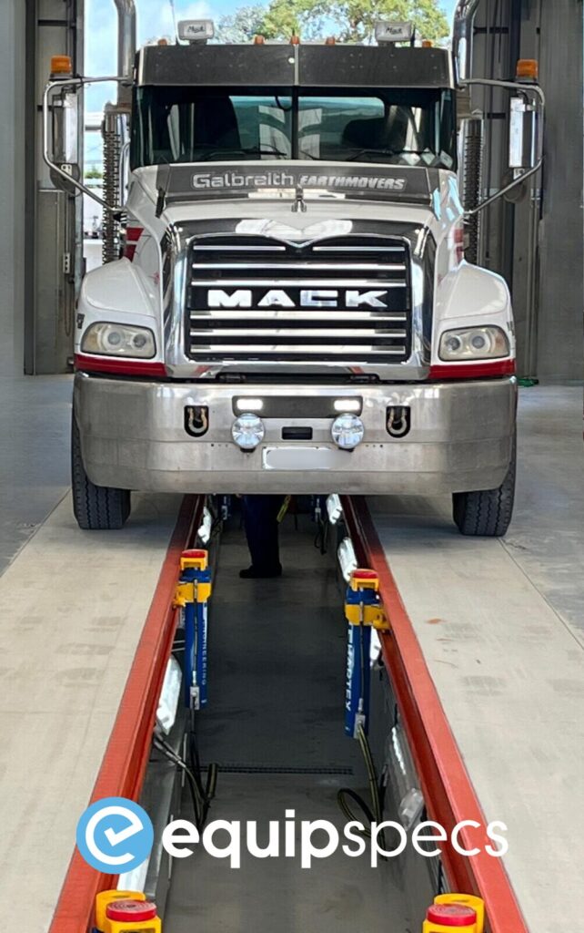 Truck driving over a prefabricated steel inspection pit installed by EquipSpecs. 