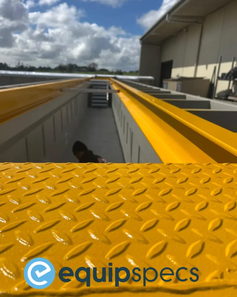 Close-up of EquipSpecs prefabricated steel inspection pit with custom yellow painted grating, demonstrating colour options and safety-focused finishes.