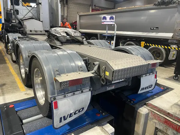 Heavy vehicle positioned on a roller brake tester during load-simulated brake testing in New Zealand